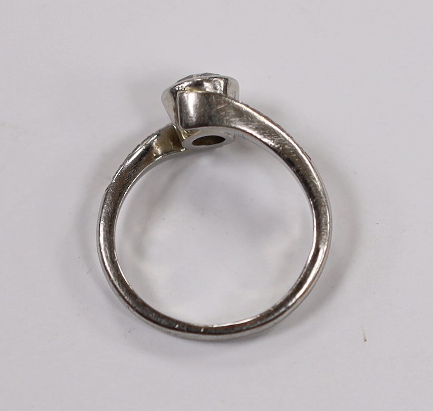 A modern platinum and collet set single stone diamond ring with diamond chip set crossover shoulders, size K, gross weight 5.5 grams